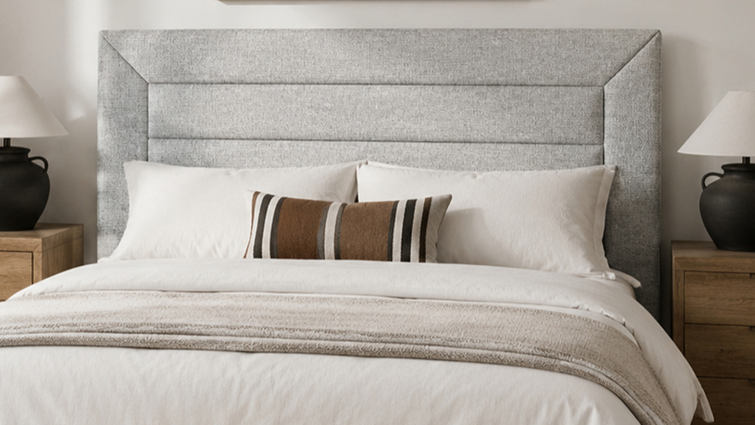 Sydney Super King Upholstered Headboard with framed panel detailing, white pillows, and a striped decorative cushion
